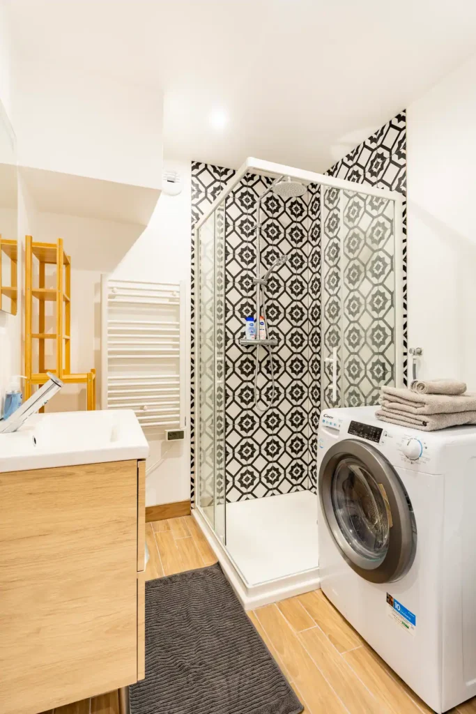Salle de bain avec douche et lave-linge